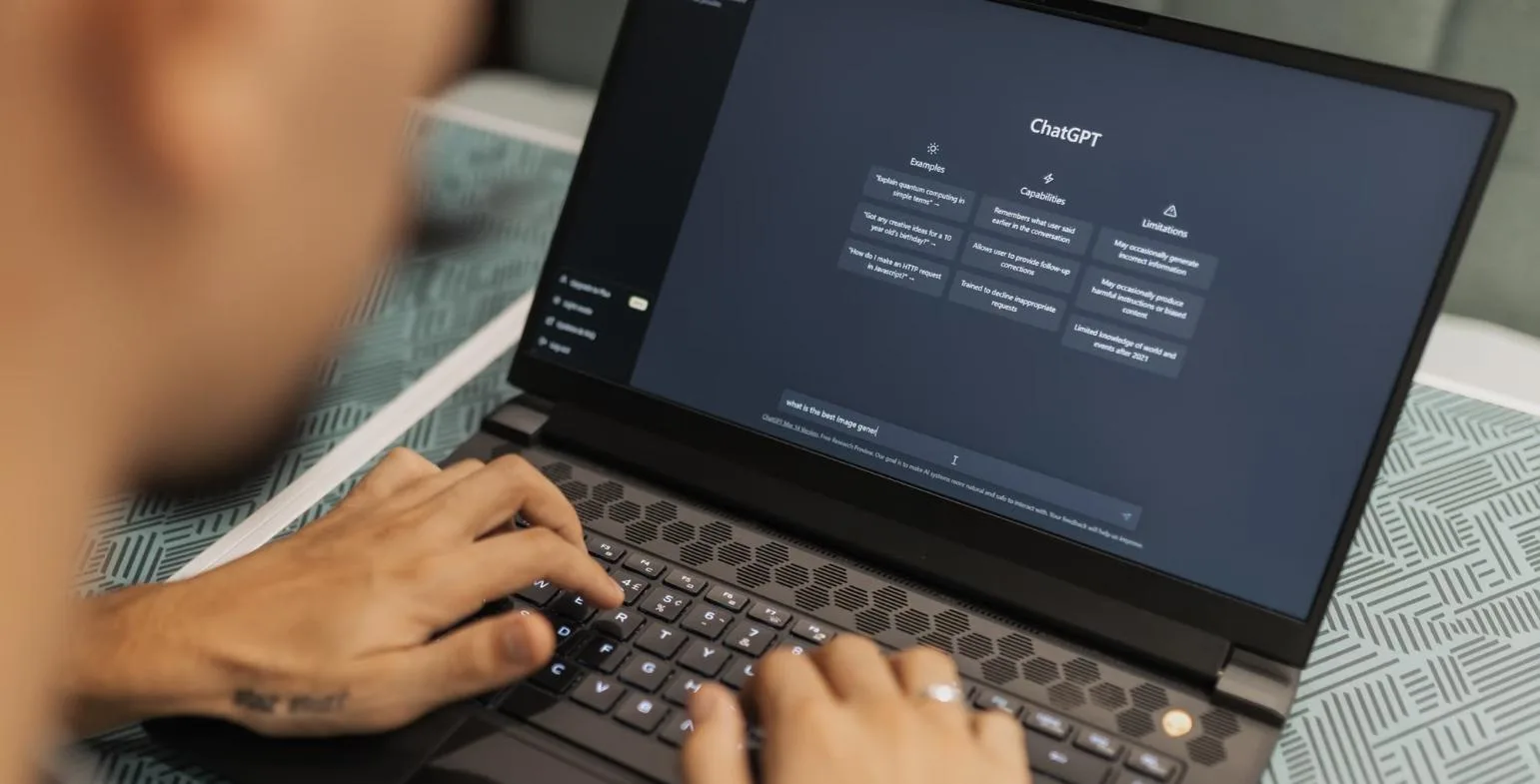 Person typing a prompt into the ChatGPT interface on a laptop