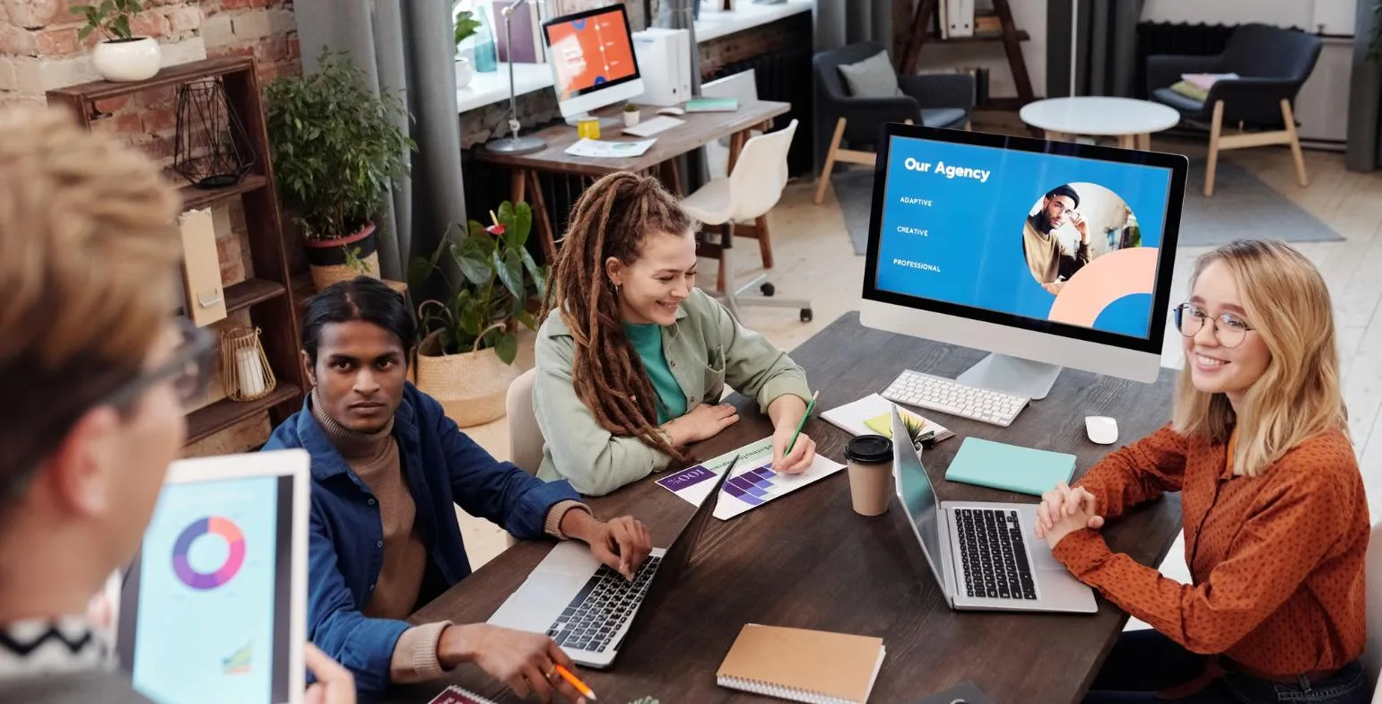 Marketing agency team reviewing an agency presentation on a monitor in a modern office
