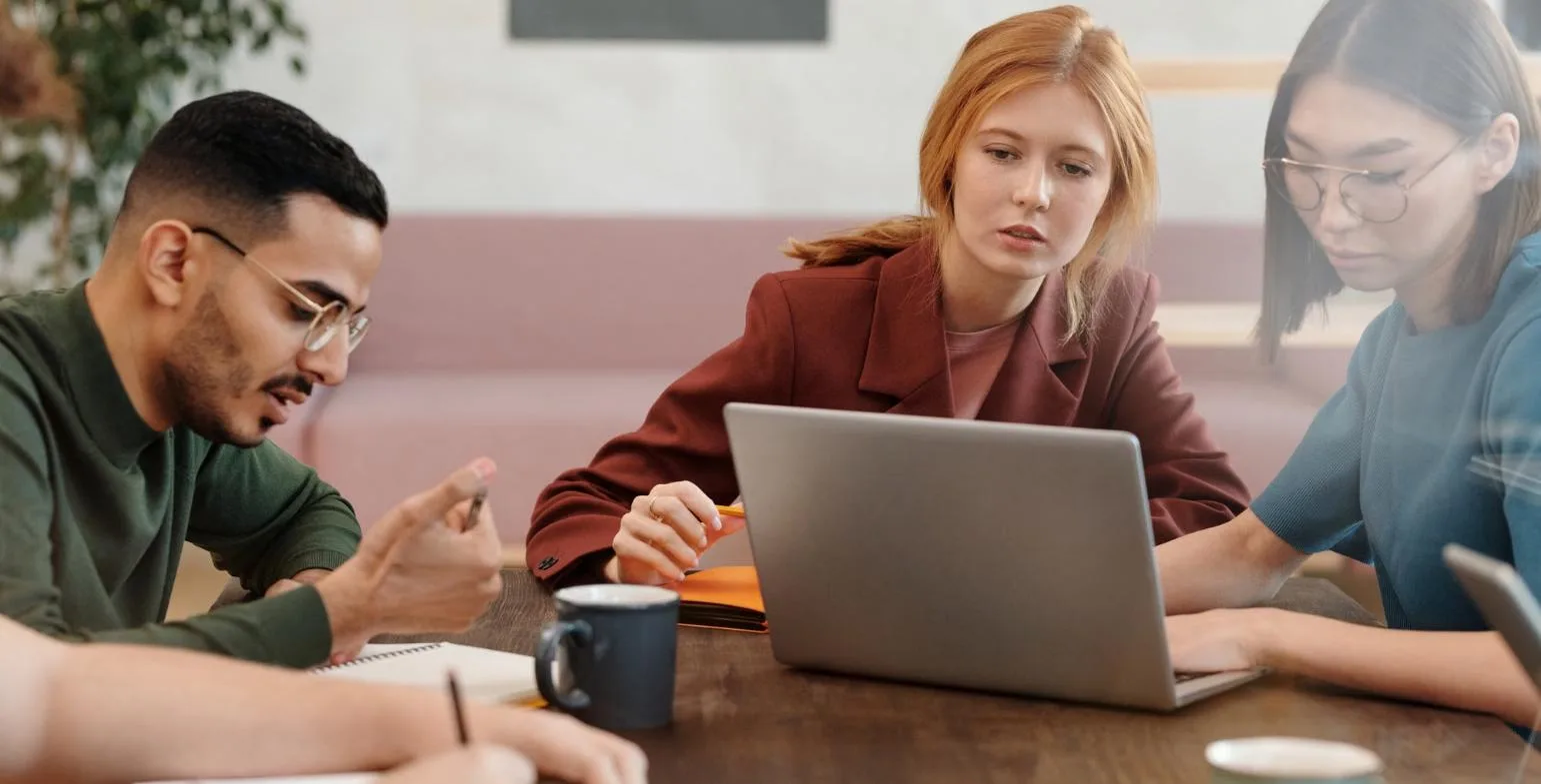 B2B SaaS team reviewing results together around a laptop in a modern office