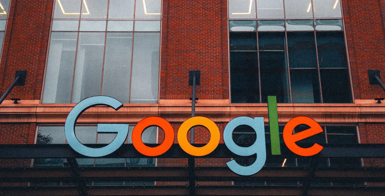 Large colourful Google logo sign on the facade of a brick office building
