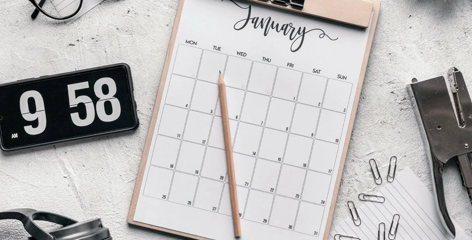 Monthly planning calendar on a clipboard with a pencil, used for content strategy