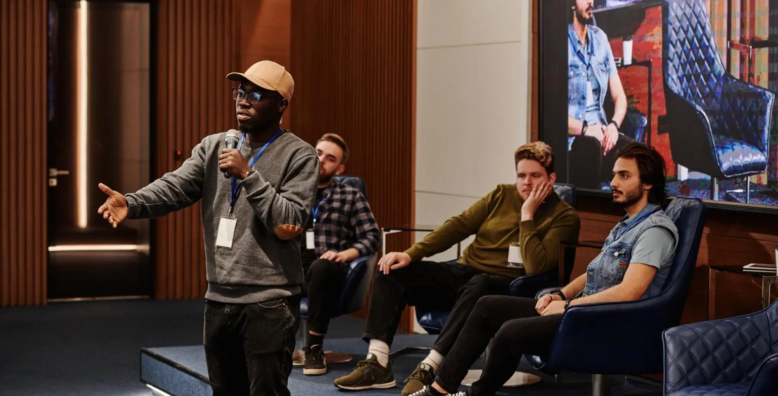 Expert speaking with a microphone on a panel while other specialists listen