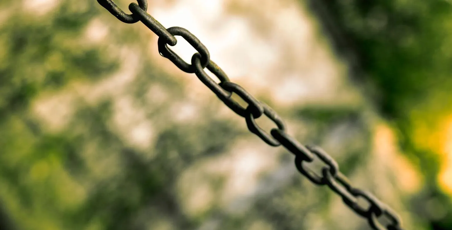 Close-up of a dark metal chain with interlocking links