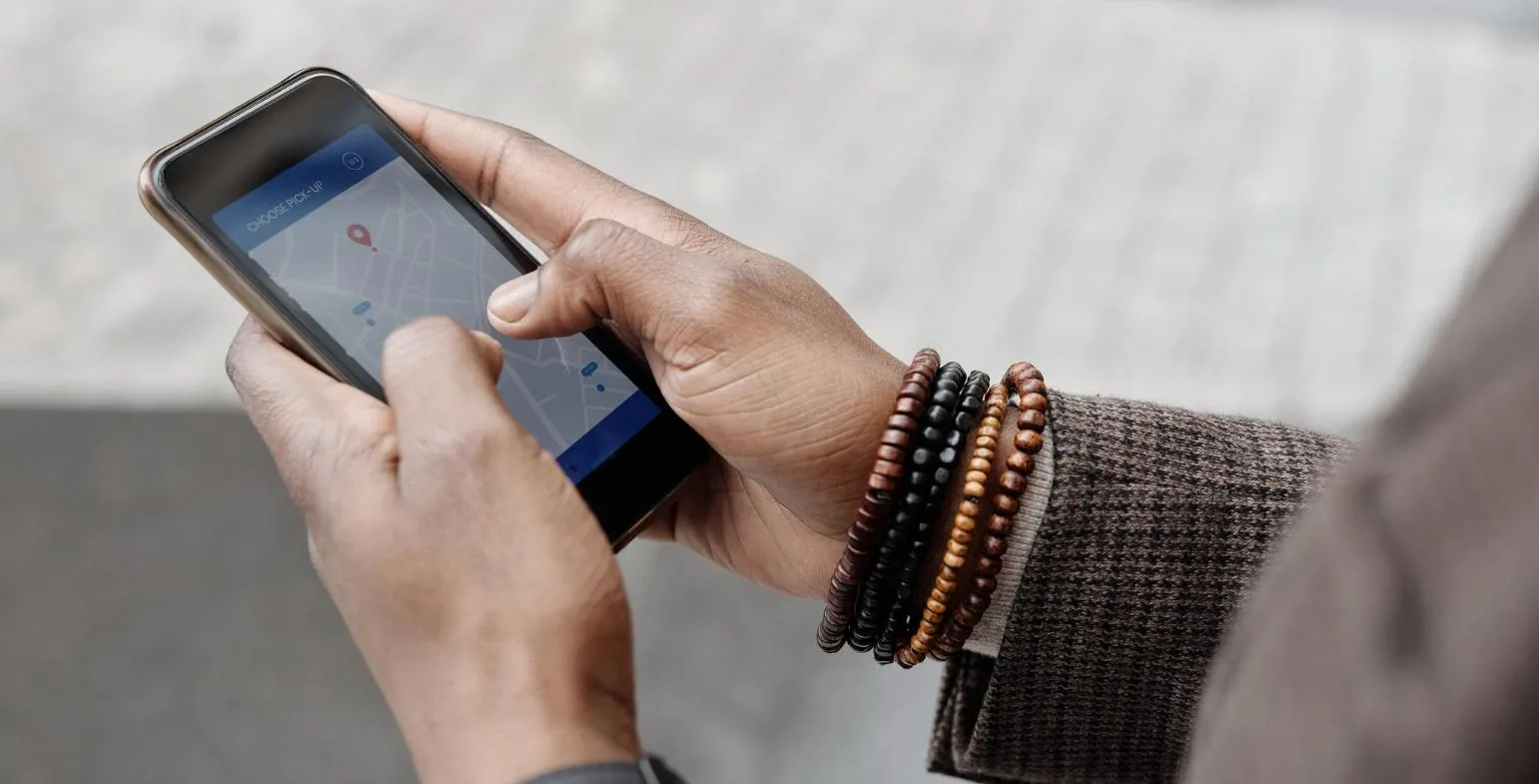 Hand holding a smartphone showing a local map with a location pin