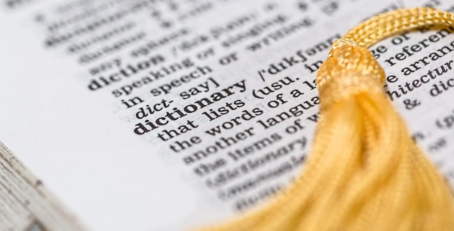 Close-up of a printed dictionary page showing the definition of the word dictionary