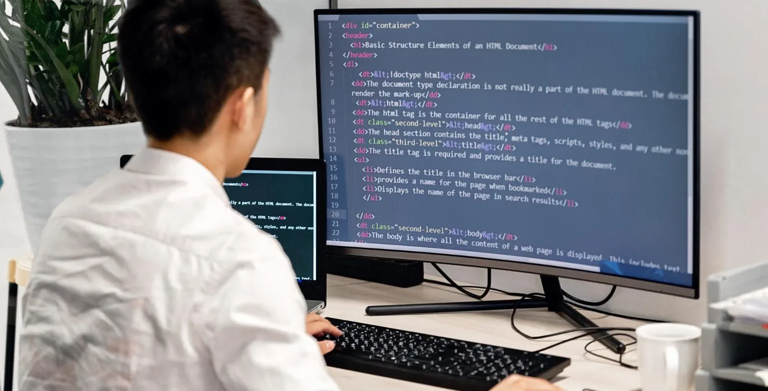 Developer reviewing HTML document structure on a large monitor
